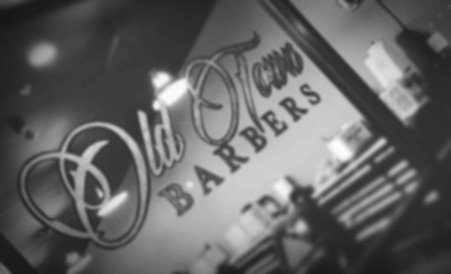 Black and white photo of the Old Town Barbers window signage