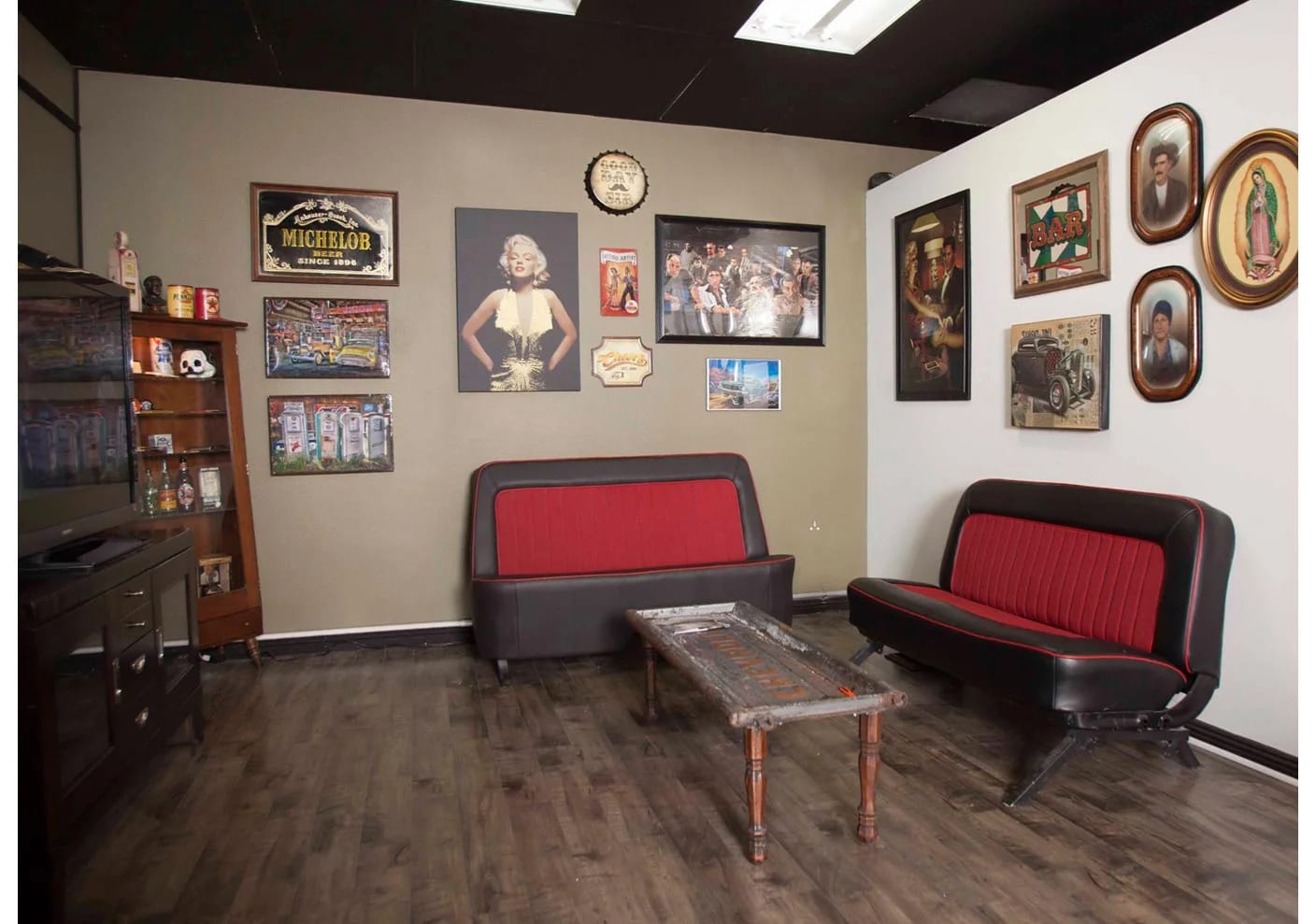 Waiting lounge with red and black bench seating and framed vintage wall art